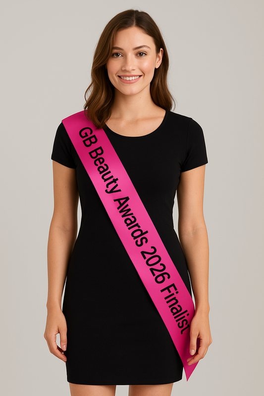 Woman wearing hot pink GB Beauty Awards 2026 Finalist sash with black lettering over black dress